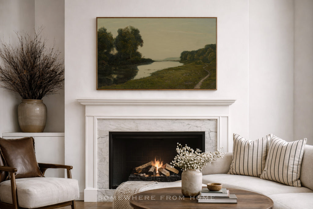 Living room with a fireplace, sofa, and large oversized muted landscape art print