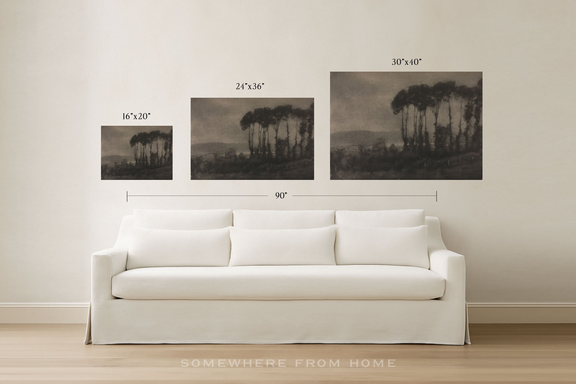 Three framed wall art prints showing dark tree silhouettes in a moody landscape, displayed above a white sofa in a bright room. Black dimension lines and text indicate the sizes of each print and the total width.