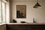 Modern kitchen with dark wood cabinets, white countertop, and a framed artwork on the wall.