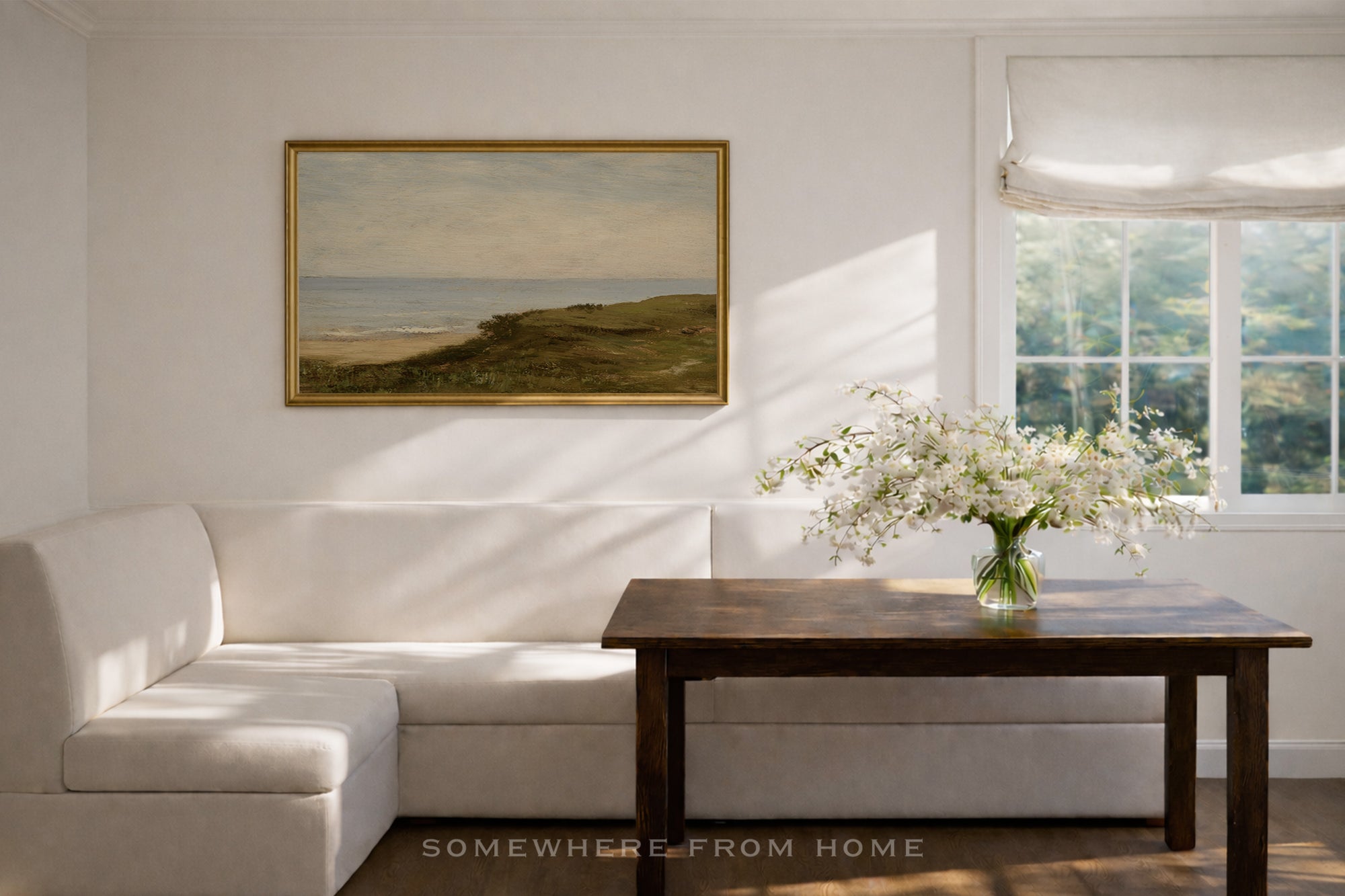 Dining room with white L Shaped banquette , wooden dining table, and framed green and blue landscape painting.