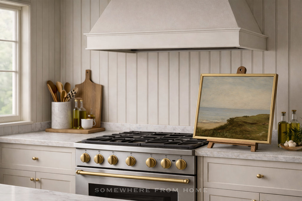 Modern farmhouse kitchen with two tone brass and stainless steel stove and decorative painting on a countertop styled on an easel