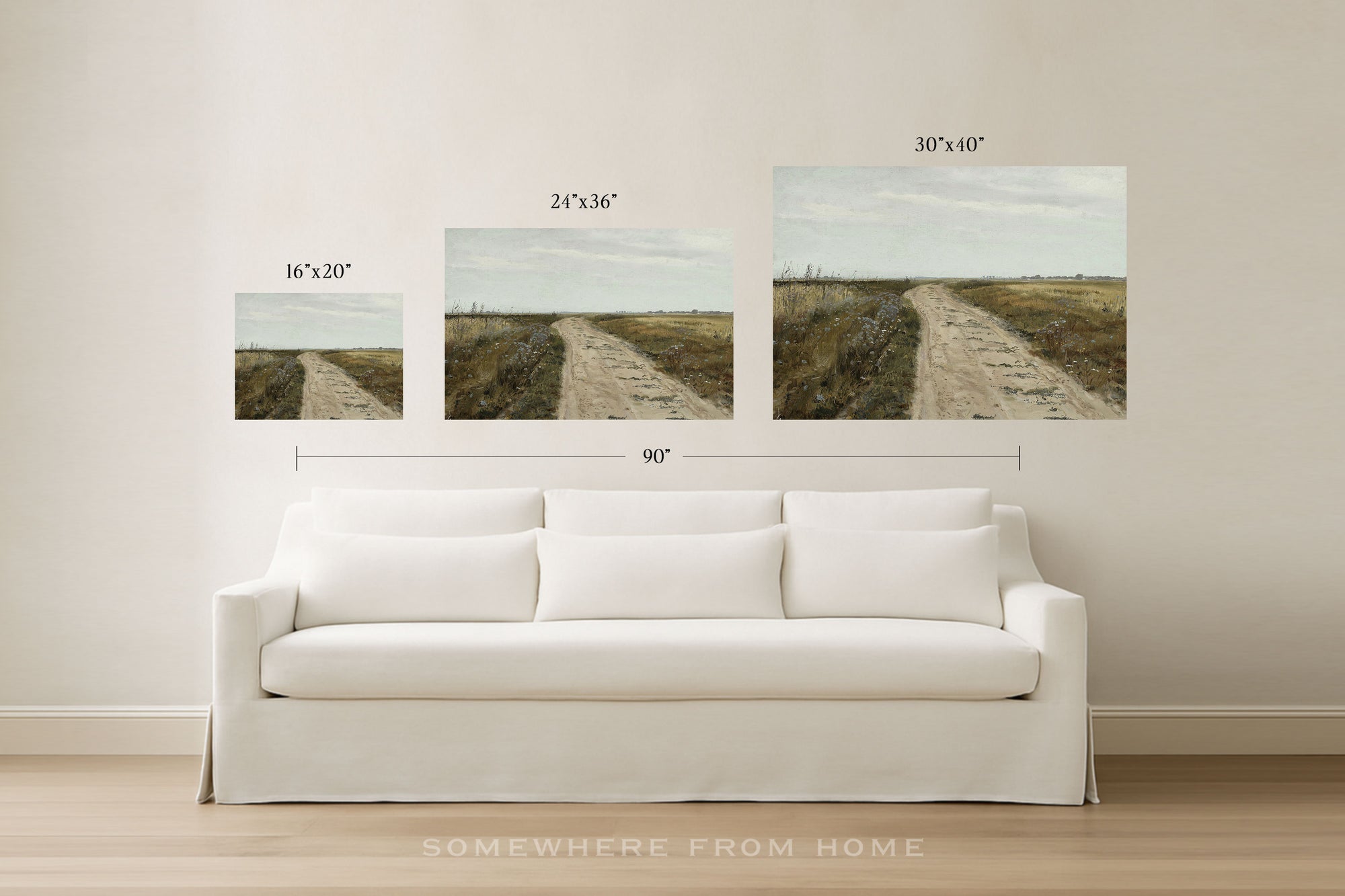 Three framed wall art prints showing a dirt road through a grassy landscape, displayed above a white sofa in a bright room. Size labels for the prints and a total width of 90 inches are overlaid, with the text 'SOMEWHERE FROM HOME' at the bottom.