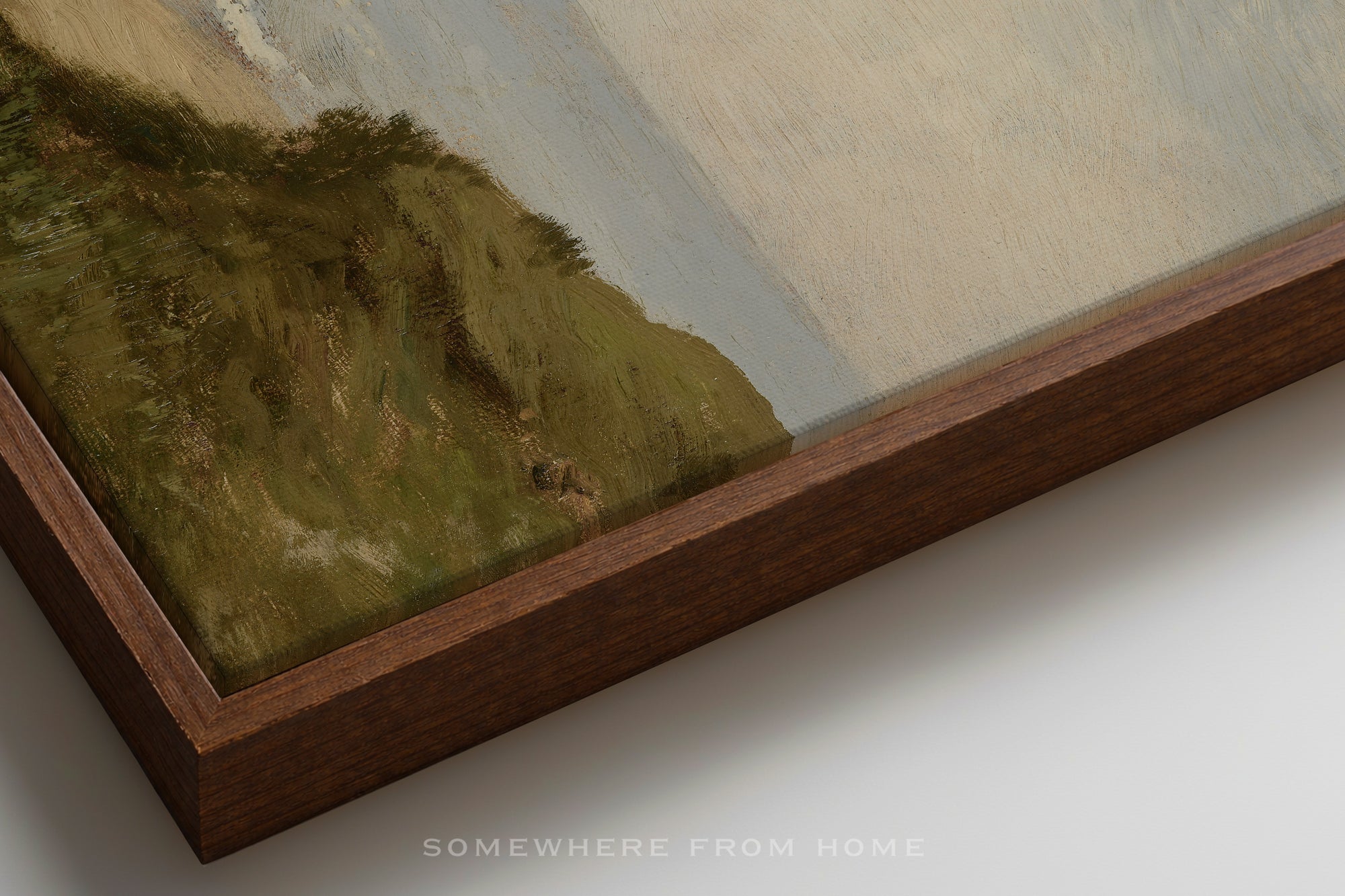 Framed neutral green and blue landscape painting with a wooden border on a white surface