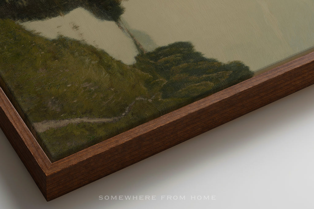 Framed artwork of a landscape with a wooden border on a white surface.