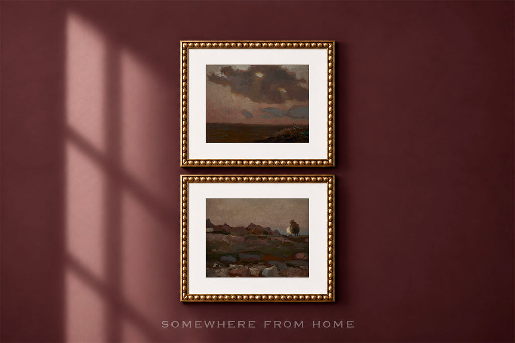 Two framed landscape paintings with white mats and ornate gold frames, displayed vertically on a dark burgundy wall with window shadow casting across the left side. Text at the bottom reads 'SOMEWHERE FROM HOME'.