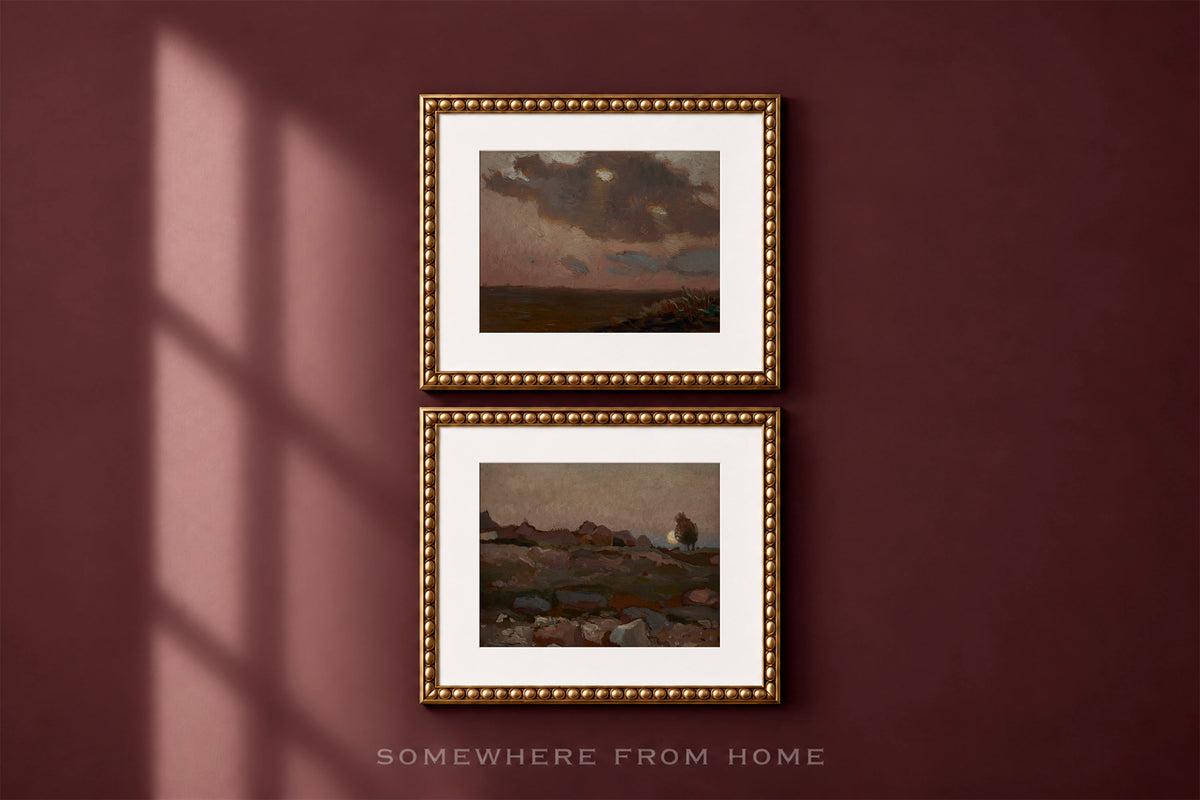 Two framed landscape paintings with white mats and ornate gold frames, displayed vertically on a dark burgundy wall with window shadow casting across the left side. Text at the bottom reads 'SOMEWHERE FROM HOME'.