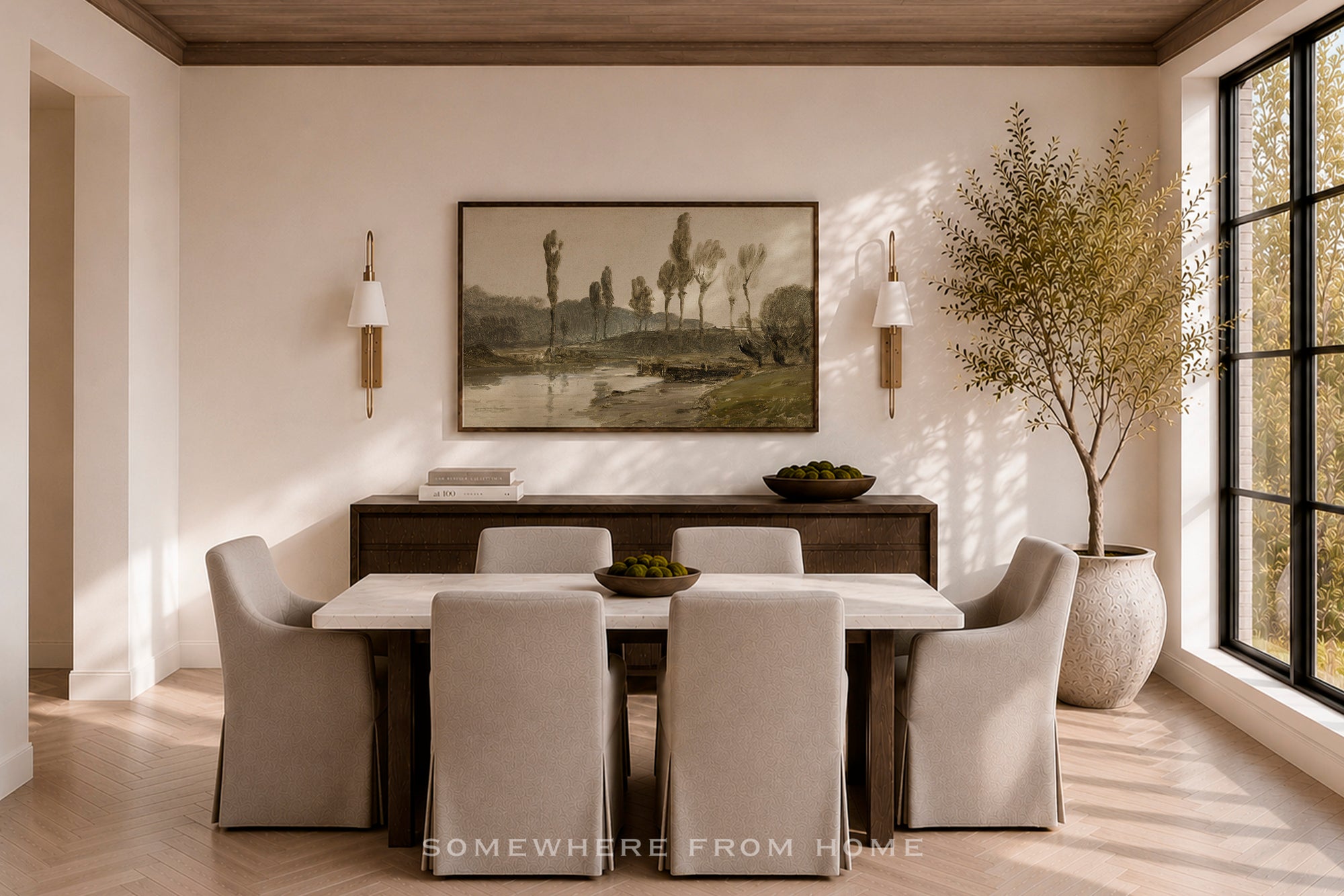A styled dining room interior featuring a rectangular dining table with six upholstered chairs, a dark wood sideboard, a framed landscape painting on the wall, wall sconces, a large potted tree, and a tall window with black frames.