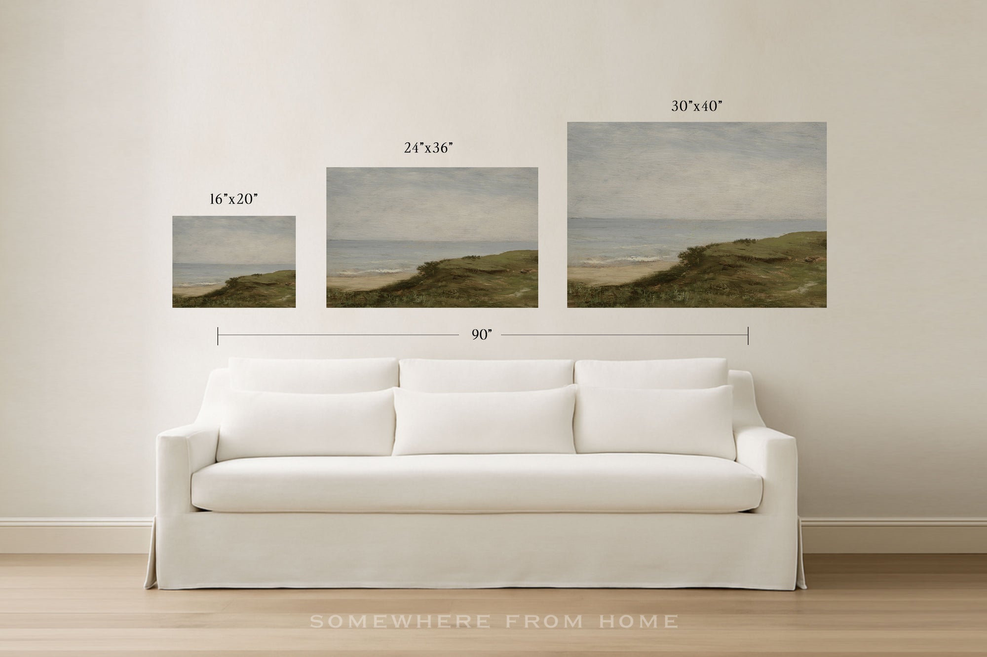 Three framed wall art prints showing coastal dune landscapes in different sizes, displayed above a white sofa in a bright room. Black text above each print indicates dimensions, and a larger 90" width measurement is shown across the set.