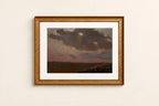 A framed landscape painting featuring a dark, moody sky over a flat horizon, presented in a textured gold frame with a white mat against a light beige wall.