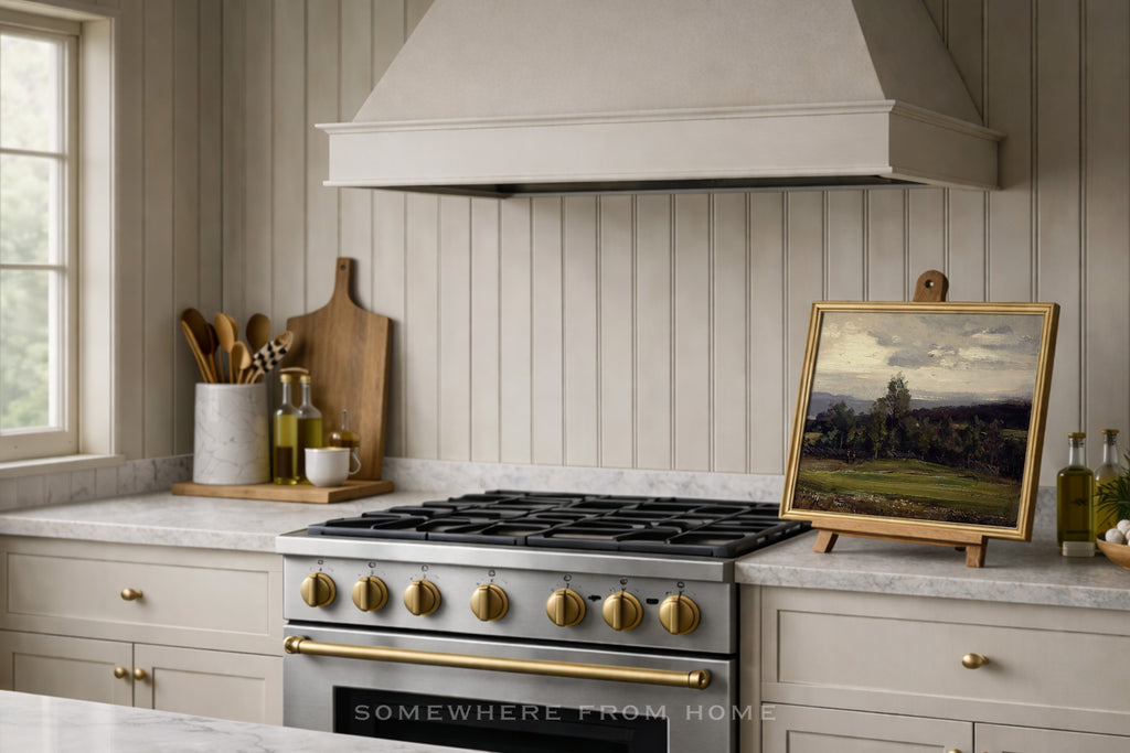 moody green landscape painting of a golf course fairway in a beige cream kitchen with beadboard and two tone oven- somewhere is home art prints and framed artwork