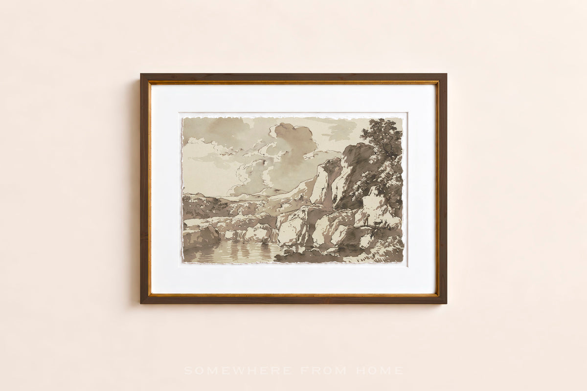 A framed art print featuring a sepia-toned landscape sketch with mountains, trees, and water, displayed on a light beige wall.