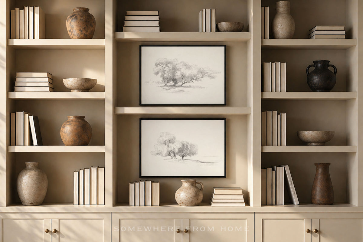 A styled interior scene showing built-in light wood bookshelves with books, ceramic vases, bowls, and two framed black-and-white tree sketches. The image appears to be a room scene rather than a clean isolated product shot, and no single sellable product is clearly centered as the subject.