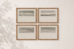 Four framed black and white landscape sketches arranged in a 2x2 grid on a warm beige wall, with soft leaf shadows cast across the left side.