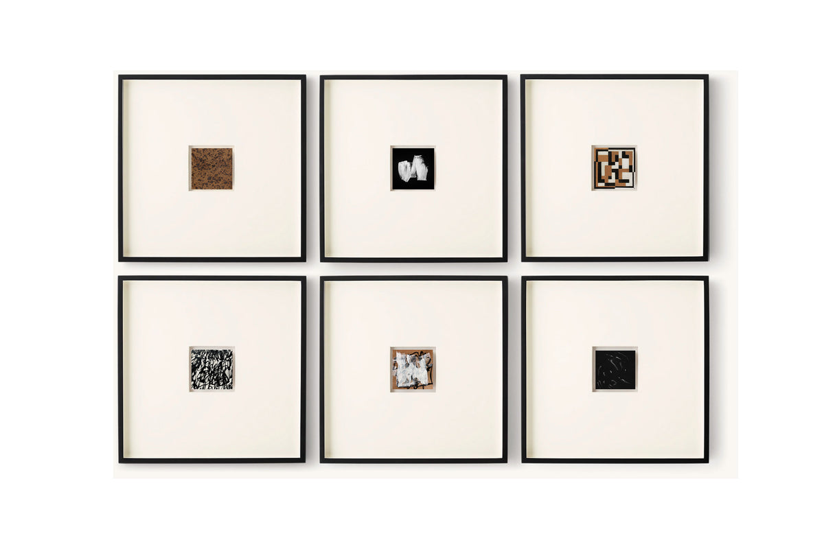 Six framed square art pieces arranged in a 2x3 grid on a white wall. Each frame has a black border and a cream mat, displaying small abstract or textured square artworks in different colors and patterns.