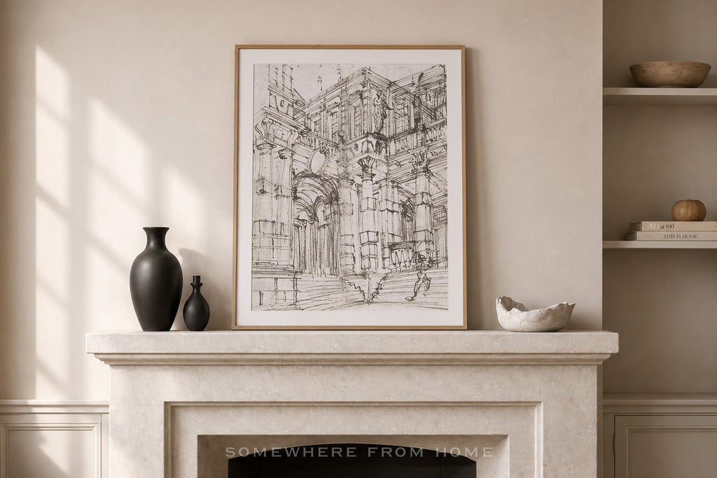 A framed black and white architectural sketch print hangs on a beige wall above a stone fireplace mantel styled with dark vases and a small bowl.